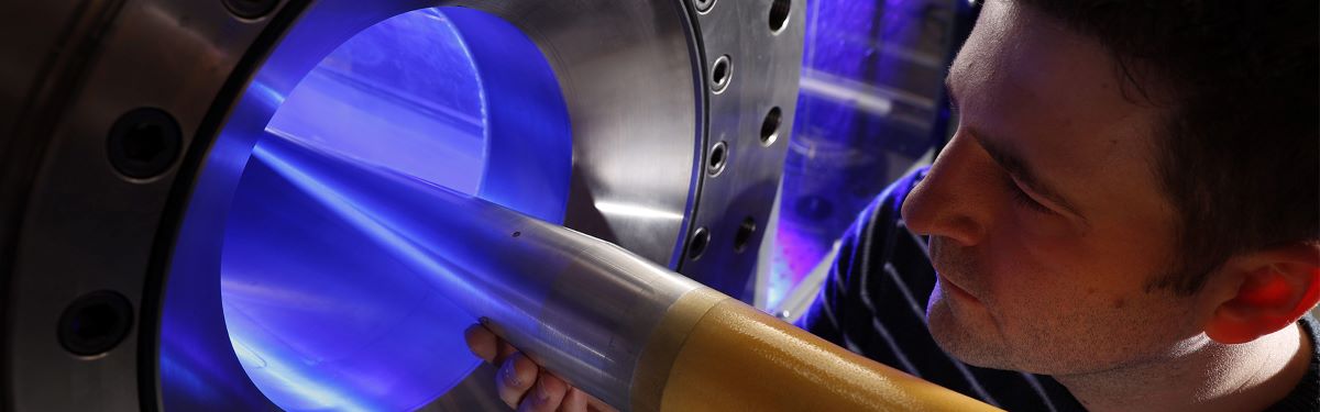 student loading an object into a hypersonic wind tunnel test chamber