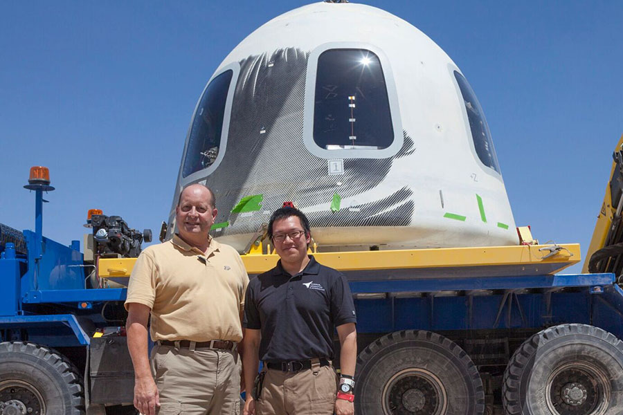 Steven Collicott, professor of aeronautics and astronautics at Purdue, and Shih-Pin 'Benny' Cheng, an undergraduate student in Collicott’s Zero-Gravity Flight Experiment class, stand in front of the New Shepard crew capsule at the Blue Origin facility in Texas. (Photo/Blue Origin)