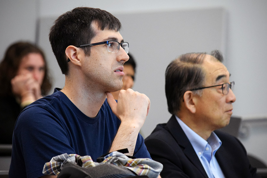 A student and a professor seated in a lecture hall