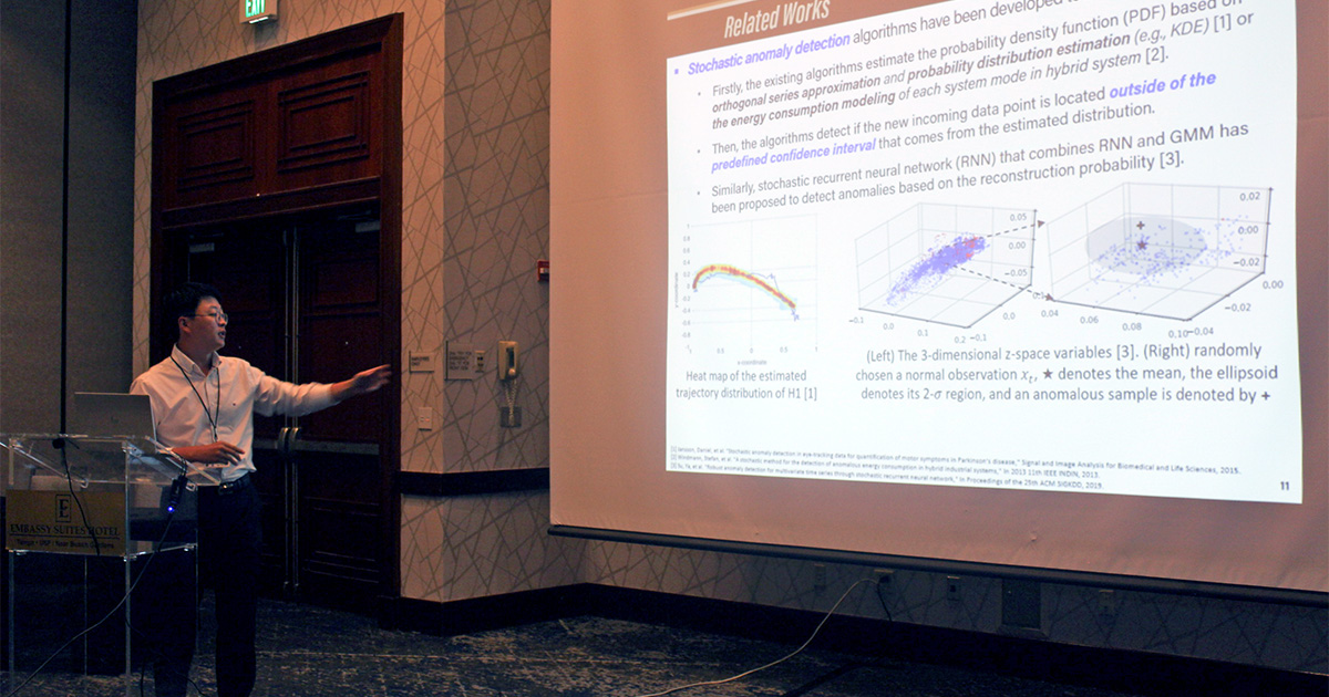 Hong-Cheol Choi presenting a slide on his work in a hotel conference room