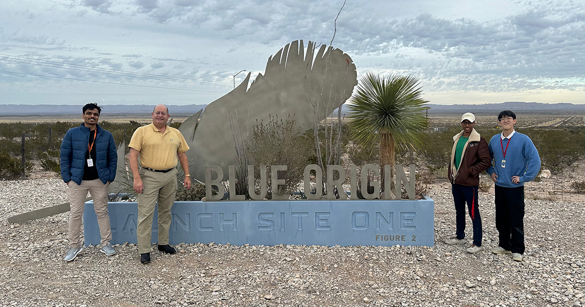 four people standing in front of the Blue Origin Launch Site 1 sign