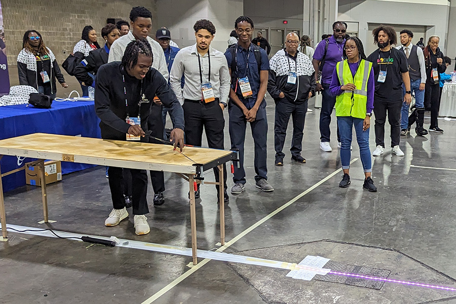 The Purdue Skywalkers team stand with a large novelty check for $400