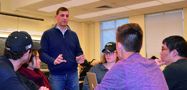 Civil Engineering Associate Professor Joseph Sinfield offers suggestions to the student group consisting of (from left) Santiago Balzaretti, Vanessa Bahk, Eleanor Ericson, Ford Fisher and Yu-Chung Lin. The group has been tasked with the issue of reducing traffic in large cities.