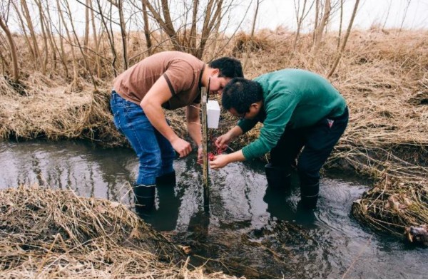 Materials engineering masters student Jose Waimin and electrical and computer engineering postdoctoral researcher Hongjie Jiang set up a soil sensor.