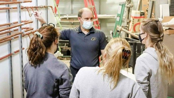 Professor Andrew Whelton prepares to gather samples with (from left) Purdue Civil Engineering undergraduate Laura Gustafson, Environmental and Ecological Engineering PhD student Aliya Ehde, and Environmental and Ecological Engineering masters student Caroline Jankowski.