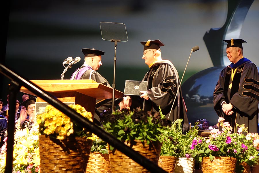 edmund schweitzer receiving his honorary doctorate from mitch daniels