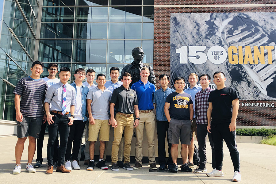 Group of poeple standing in front of Neil Armstrong statue.
