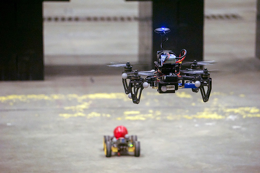 Drone hovering over small vehicle.