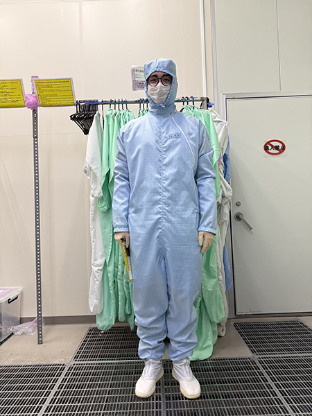 Student wearing protective suit in a lab, facemask, glasses