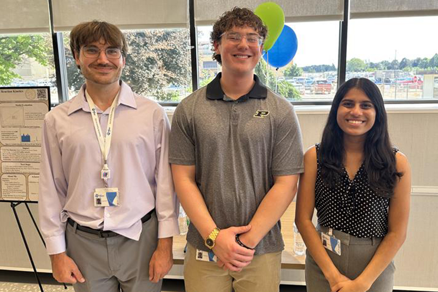 Three students standing smiling