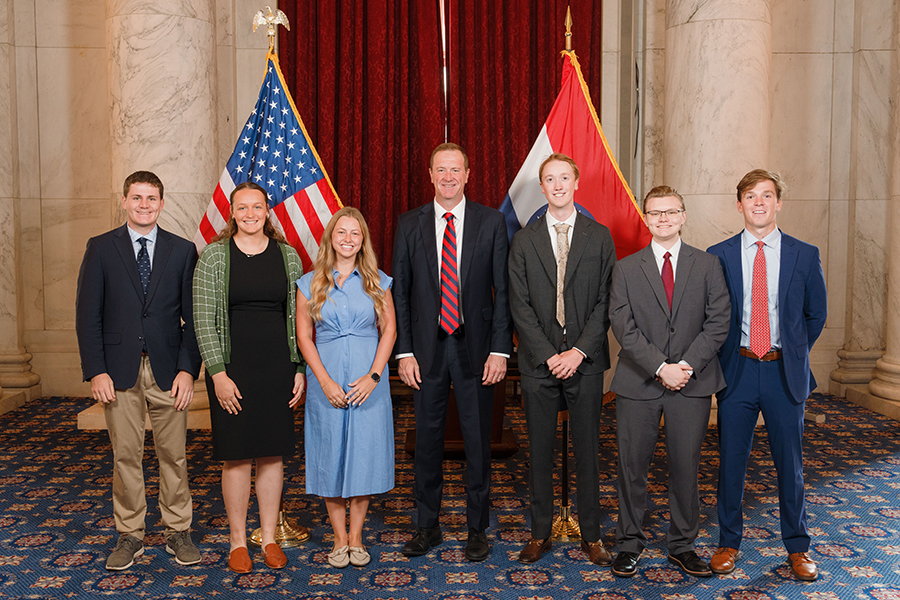 Group of people standing in front of flags